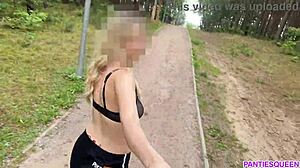 La mujer rubia hace ejercicio al aire libre en el parque, exponiendo su cuerpo desnudo y sus pechos rebotando