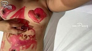 O adolescentă schițează pe corpul ei asiatic gol cu rujuri într-un videoclip de casă